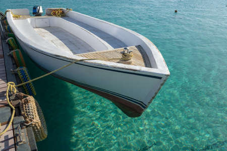 White boat near pier. Transparent sea in background.の写真素材