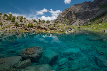 Blue and transparent lake in Fann Mountains. Blue sky with white clouds in background. Domestic...