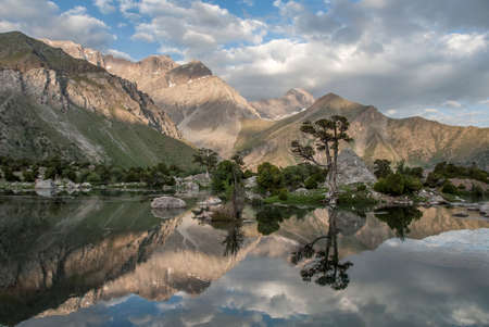 Tranquil Kulikalon lake as mirrow in wich trees, mountain and sky reflect.の写真素材