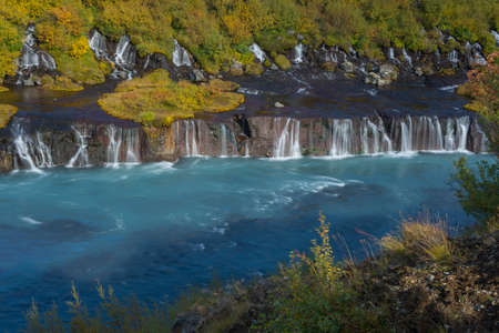 Barnafoss waterfall in autumn season. Yellow trees are over waterfalls.の写真素材