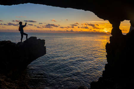 Woman sitting on a rocket and looking at a photo with help of a device (smartphone). Rock withの写真素材