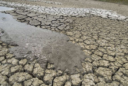 Mud volcano flows over cracked earth.