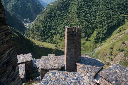 Stronghold Mutso against green valley background. Clearly visible stone roofs. Khevsureti (Georgia),...