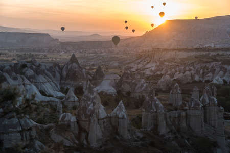 Hot-air balloons against sunrise scene. Cappadocia. Famous Cappadocia rocks in foreground.のeditorial素材