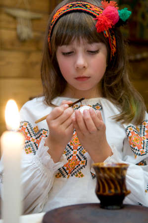 Kolomyia, Ivano-Frankivsk Oblast/Ukraine - 10.07.2008. Girl dressed in Ukrainian folk costumes paints eggs for Easter.のeditorial素材