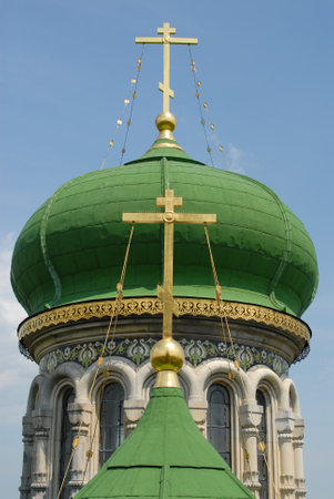 Green domes of Assumption Cathedral in Bila Krynytsia. The domes are arranged so that the golden crosses are located on the same vertical line. Blue sky in background.の写真素材