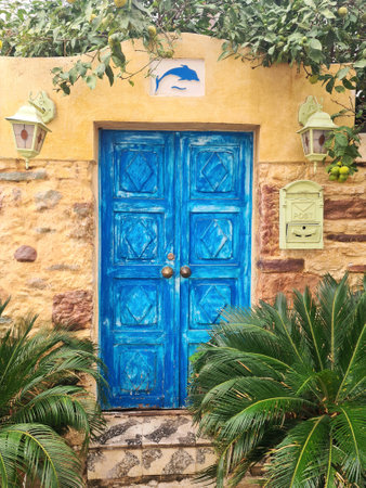 Old blue door in Bodrum. Door is framed by lush green vegetation.の写真素材