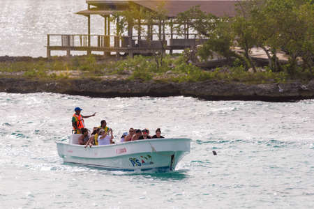 BAYAHIBE, DOMINICAN REPUBLIC - MAY 21, 2017: Tourists in a boat by the shore. Copy space for textのeditorial素材