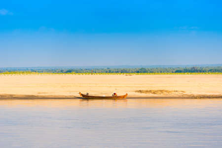 MANDALAY, MYANMAR - DECEMBER 1, 2016: A fisherman on the shore of the Irrawaddy river, Burma. Copy space for textのeditorial素材