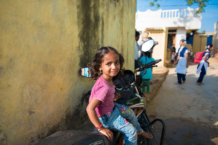 PUTTAPARTHI, ANDHRA PRADESH - INDIA - NOVEMBER 09, 2016: Indian girl sitting on a motorcycle. Copy space. Space for textのeditorial素材