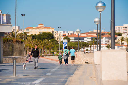 MIAMI PLATJA, SPAIN - APRIL 24, 2017:People walk along the embankment. Copy spaceのeditorial素材