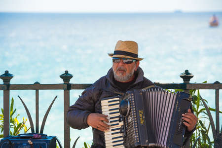 TARRAGONA, SPAIN  MAY 1, 2017: Musician on the waterfront plays the accordion. Copy space. Space for textのeditorial素材