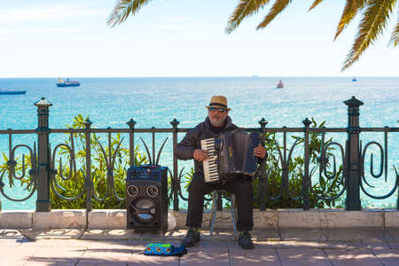 TARRAGONA, SPAIN  MAY 1, 2017: Musician on the waterfront plays the accordion. Copy space. Space for textのeditorial素材