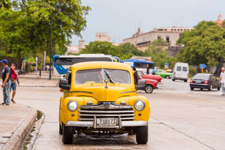 CUBA, HAVANA - MAY 5, 2017: Yellow American retro car on a city street. Copy space for text