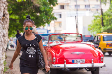 CUBA, HAVANA - MAY 5, 2017: Girl on the background of a red retro cabrioletのeditorial素材