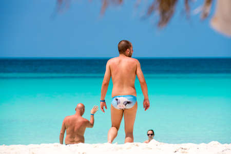 CAYO LARGO, CUBA - MAY 10, 2017: Two men and one woman on the beach. Copy space for textのeditorial素材