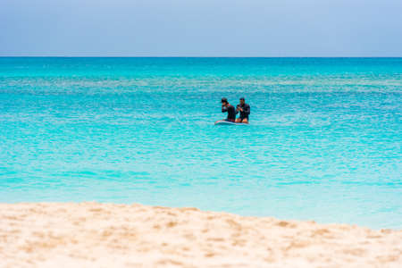 Two surfers on the beach of the Playa Paradise. Copy space for text