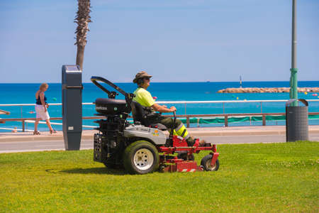 LA PINEDA, SPAIN - JUNE 6, 2017: Lawn mower on the waterfront, Tarragona, Catalunya, Spain. Copy...