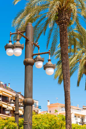 Street lamp against the blue sky, in Sitges, Barcelona, Catalunya, Spain. Copy space for text. Isolated on blue background. Verticalの写真素材