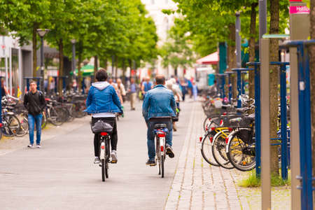 OLDENBURG, GERMANY - JUNE 10, 2017: A group of cyclists riding around the old town. Copy space for textのeditorial素材