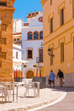 SITGES, CATALUNYA, SPAIN - JUNE 20, 2017: Two men walk through the historic part of the city. Copy space for text. Verticalのeditorial素材