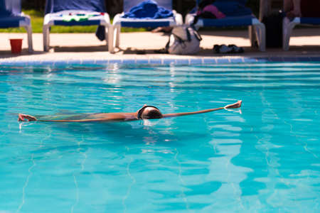 A man is swimming in the pool on his back in Varadero, Matanzas, Cuba. Copy space for textのeditorial素材