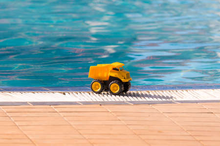 Yellow toy car on the edge of the pool, Varadero, Matanzas, Cuba. Copy space for text. Close-up