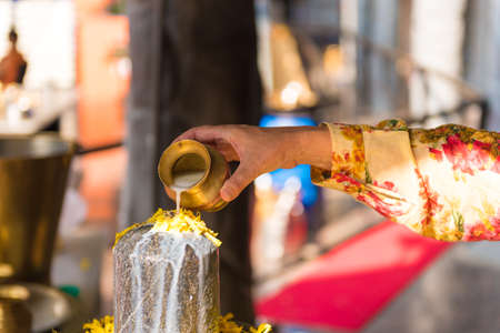 A ritual of Hindu religion. A solution of rice flour pours on the sculpture Lingam. Close-upの写真素材