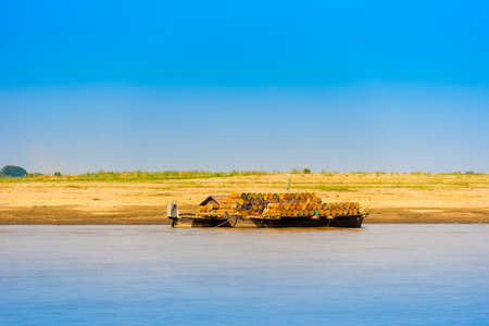 Wooden raft with barrels on the river Irravarddy, Mandalay, Myanmar, Burma. Copy space for textの写真素材