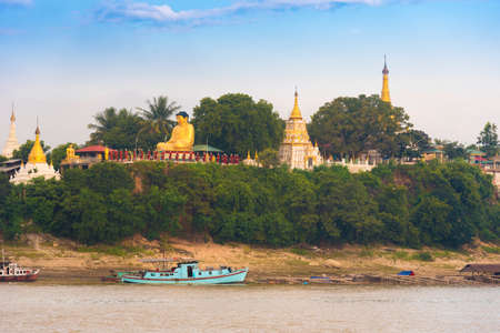 MANDALAY, MYANMAR - DECEMBER 1, 2016: Buddha statue on the bank of the river Irrawaddy, Burma. Copy space for textのeditorial素材