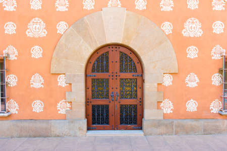 Wooden door with forged elements in Montbrio del Camp, Tarragona, Catalunya, Spain. Copy space for textのeditorial素材