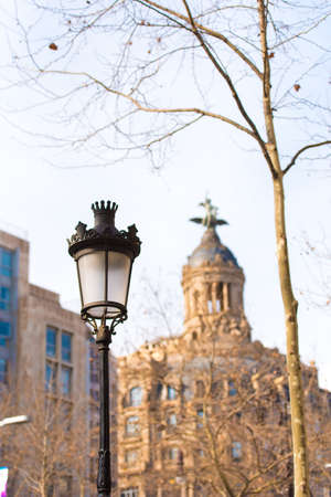 BARCELONA, SPAIN - FEBRUARY 16, 2017: Street lamp on the background of La Union y el Fenix (Barcelona - Passeig de Gracia - Barcelones). Copy space for text. Verticalの写真素材