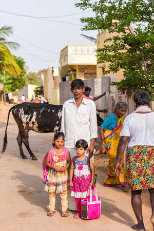 PUTTAPARTHI, ANDHRA PRADESH, INDIA - JULY 9, 2017: Indian family in a village street. Verticalのeditorial素材