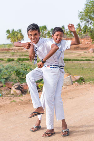 PUTTAPARTHI, ANDHRA PRADESH, INDIA - JULY 9, 2017: Two cheerful Indian boys. Vertical. Copy space for textのeditorial素材