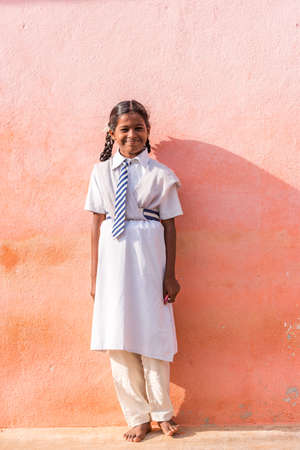 PUTTAPARTHI, ANDHRA PRADESH, INDIA - JULY 9, 2017: Indian girl in school uniform. Copy space for text. Verticalの写真素材