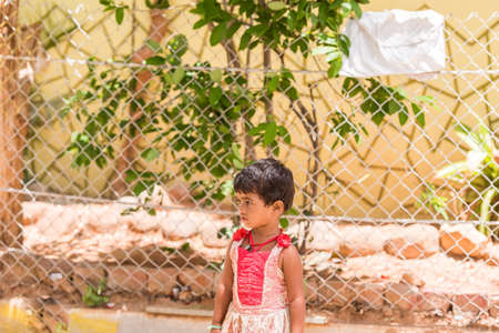 PUTTAPARTHI, ANDHRA PRADESH, INDIA - JULY 9, 2017: Happy indian girl playing on the street. Copy space for textのeditorial素材