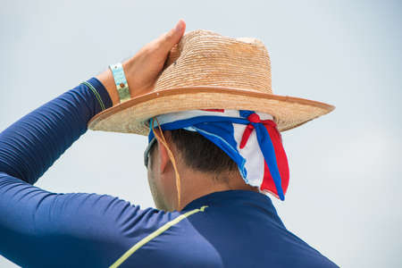 The man in the hat on the beach in Bayahibe, La Altagracia, Dominican Republic. Copy space for text. Back view. Close-upの写真素材