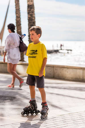 SALOU, TARRAGONA, SPAIN-SEPTEMBER 17, 2017: A boy on roller-skates by the sea. Copy space for text....