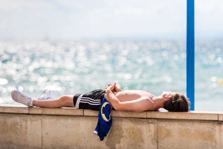 The man lies on the seafront in Salou, Tarragona, Spain. Copy space for textのeditorial素材