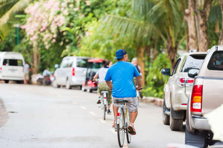 LOUANGPHABANG, LAOS - JANUARY 11, 2017: A man on bicycles on a city street. Copy space for textのeditorial素材