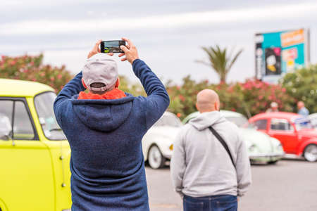 AGDE, FRANCE - SEPTEMBER 9, 2017: A man is taking pictures of cars. Copy space for textのeditorial素材