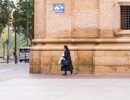 SARAGOSSA, SPAIN - SEPTEMBER 27, 2017: The nun is walking down the street. Copy space for textのeditorial素材