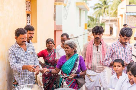 PUTTAPARTHI, ANDHRA PRADESH, INDIA - JULY 9, 2017: A group of people in line for a meal. Close-up