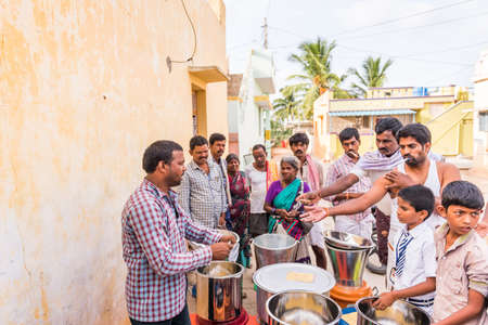 PUTTAPARTHI, ANDHRA PRADESH, INDIA - JULY 9, 2017: A group of people in line for a meal. Copy space for textのeditorial素材