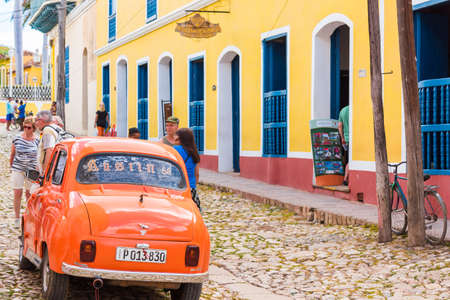 TRINIDAD, CUBA - MAY 16, 2017: Orange retro car on city street. Copy space for textのeditorial素材