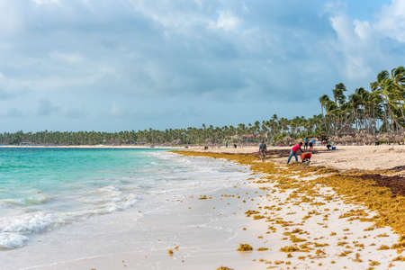 PUNTA CANA, DOMINICAN REPUBLIC - MAY 22, 2017: People clean the beach. Copy space for textのeditorial素材