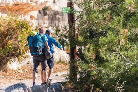 SIURANA DE PRADES, SPAIN - OCTOBER 5, 2017: Tourists with backpacks in the mountains. Copy space for textのeditorial素材