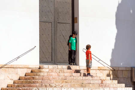 TARRAGONA, SPAIN - OCTOBER 4, 2017: Children on the stairs near the door. Copy space for textのeditorial素材