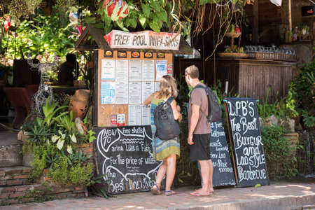 LUANG PRABANG, LAOS - JANUARY 11, 2017: A couple of tourists near a local cafe. Copy space for textのeditorial素材