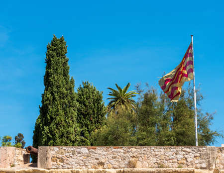 View of the fortress with cannons and flag, Tarragona, Catalunya, Spain.のeditorial素材